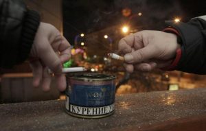 497047-men-tap-ash-from-their-cigarettes-while-smoking-on-the-balcony-of-an-office-building-in-krasnoyarsk